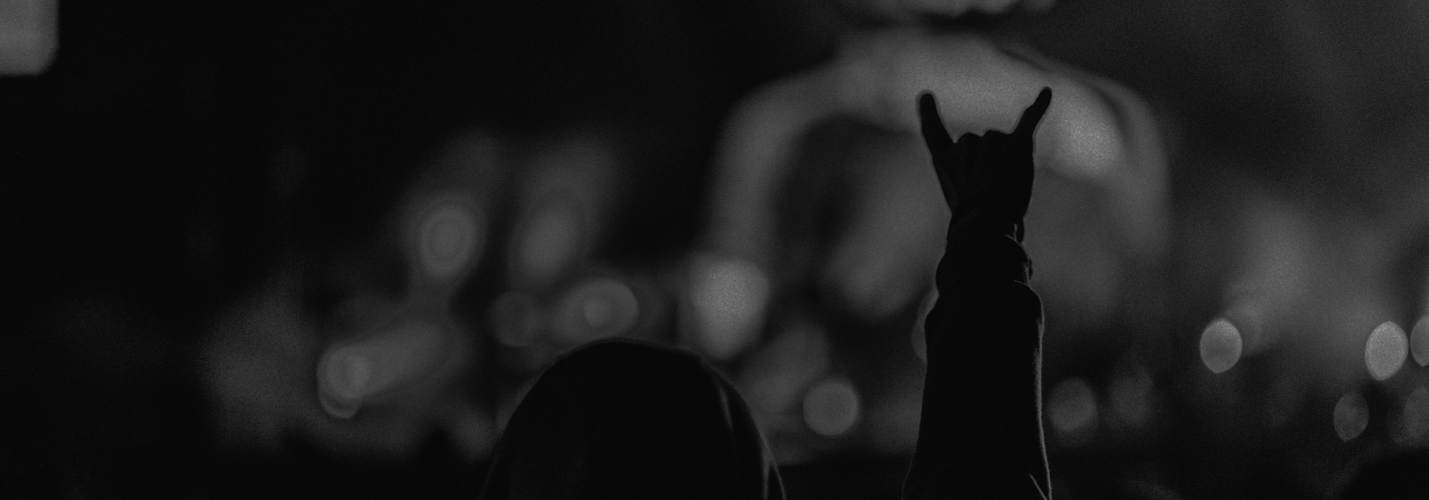 Mann von hinten hebt die hand in die luft.